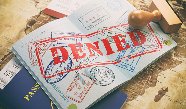 Passport with a denied US visa stamp, symbolizing US visa rejection rates.