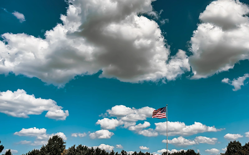 American flag waving under a cloudy sky in the USA, May.