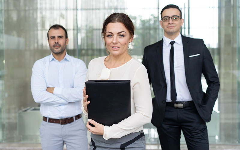 Smiling businesswoman with two colleagues at a visa interview.