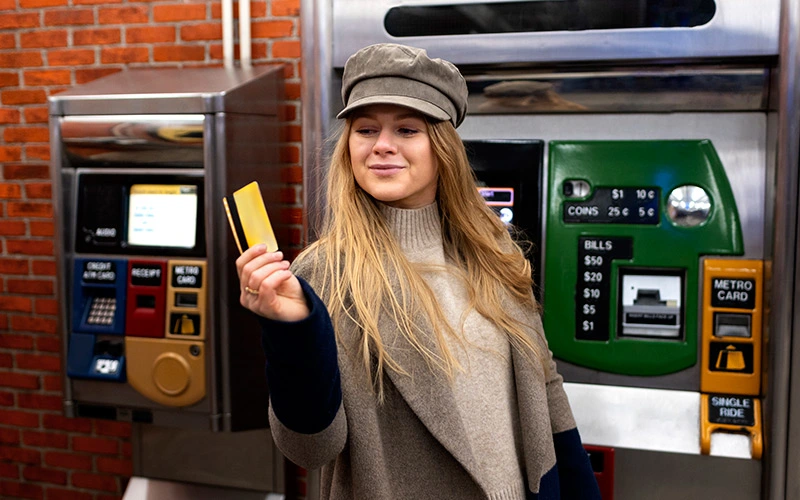 Woman swiping metro card at subway station entrance. 