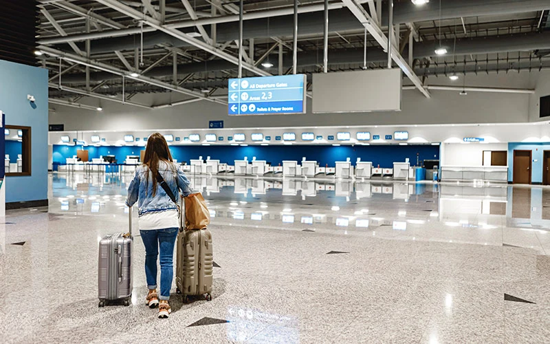 Woman walks along the airport with suitcases